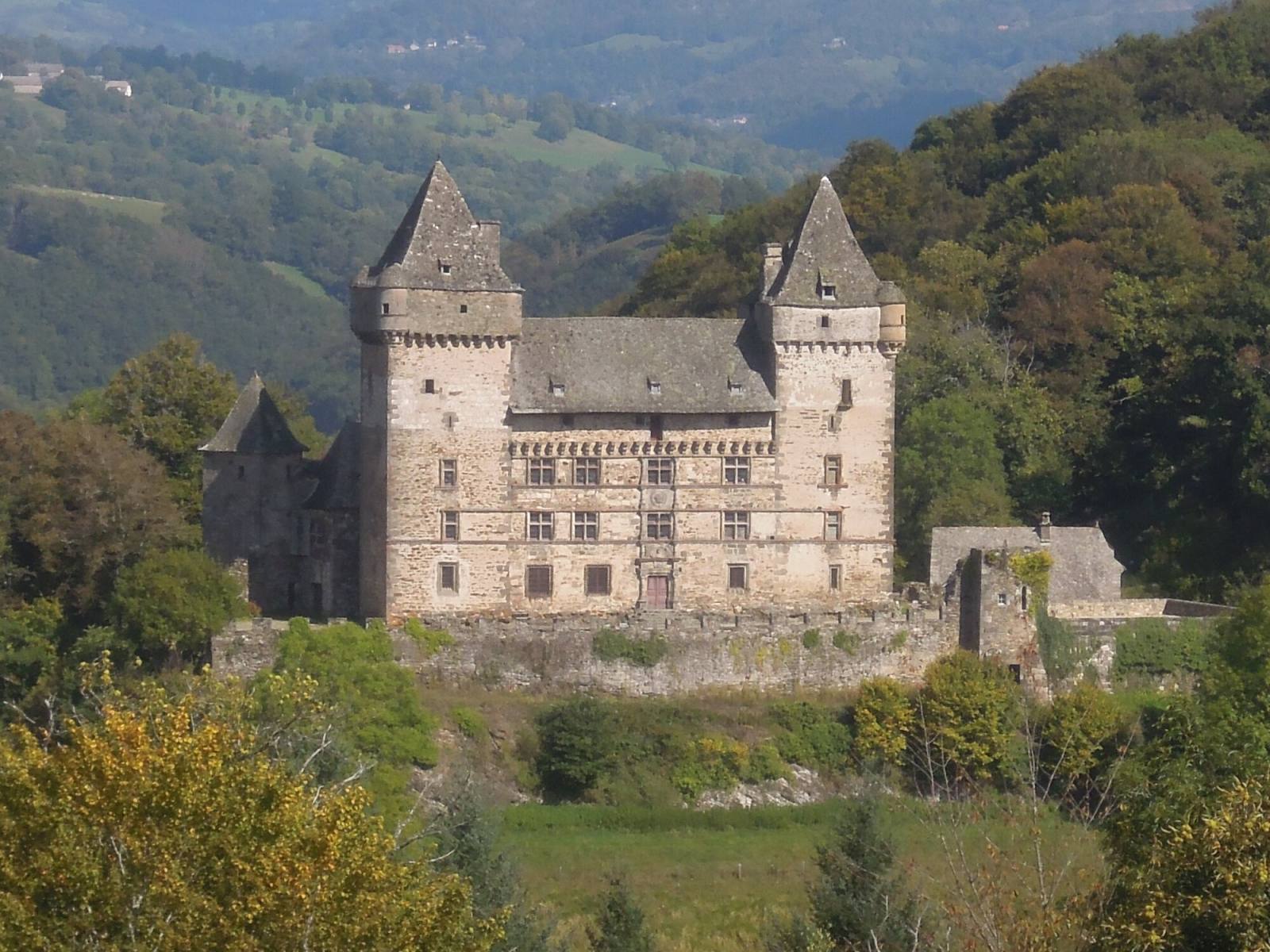 Le château de Messilhac, sa façade Renaissance entre deux tours carrées, dans la vallée boisée du Goul