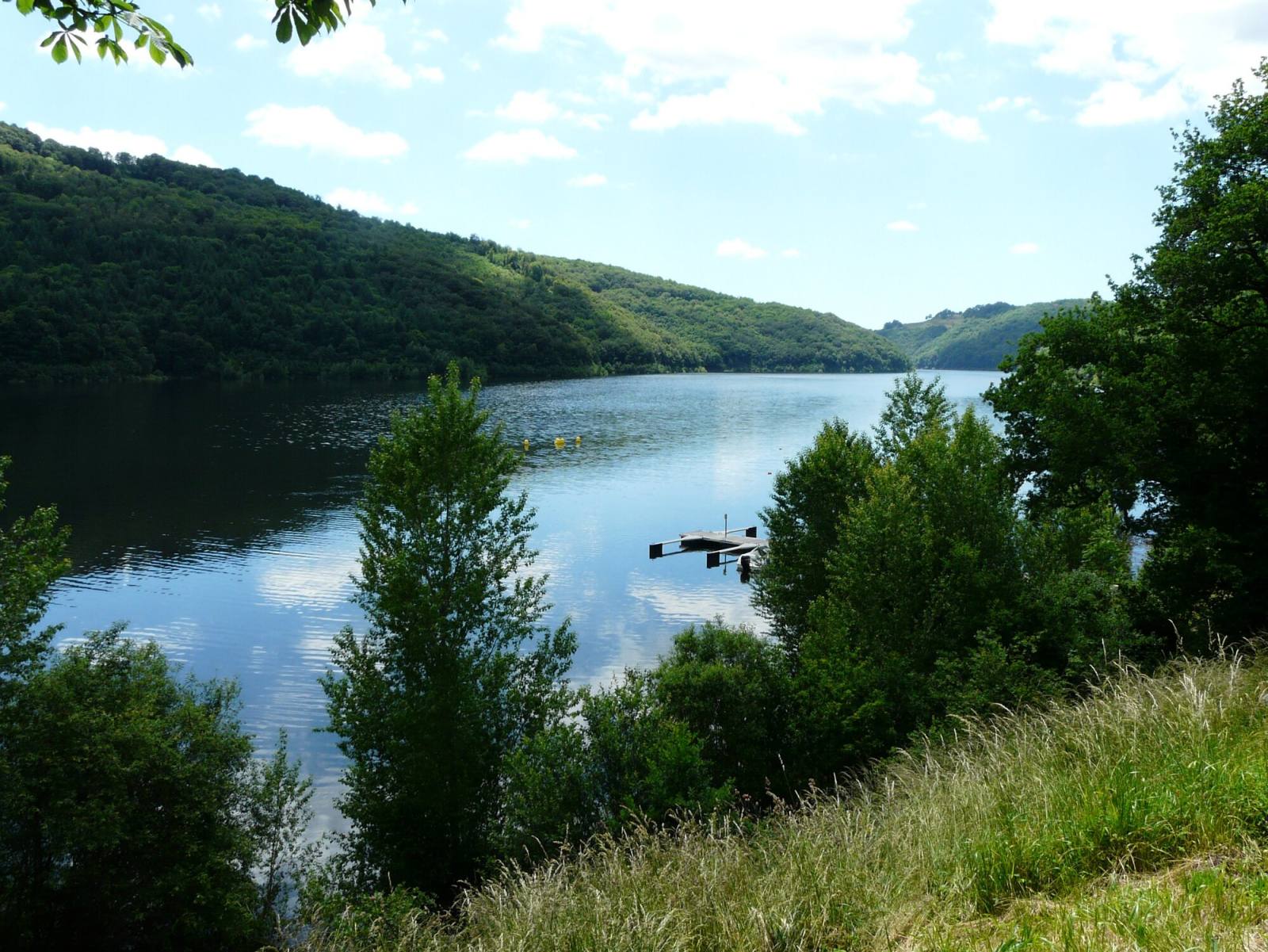 Le lac de Sarrans vu depuis la presqu'île de Laussac, entre les versants boisés des gorges de la Truyère